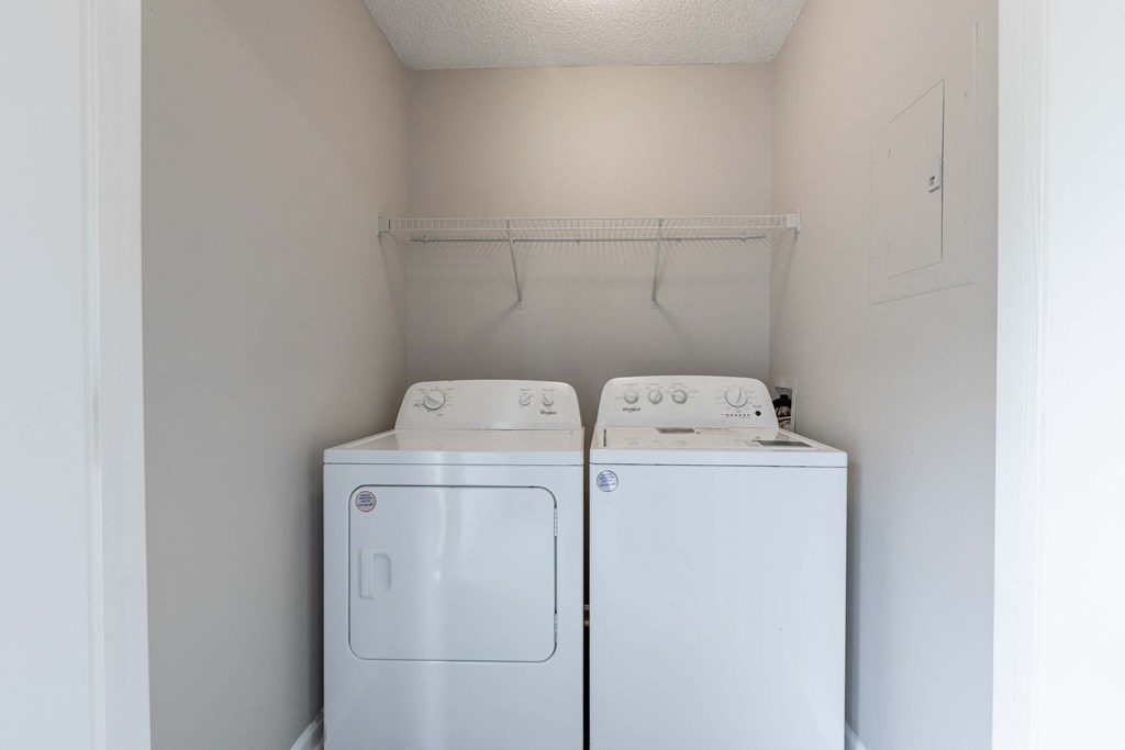 a washer and dryer in a laundry room with white walls and a white