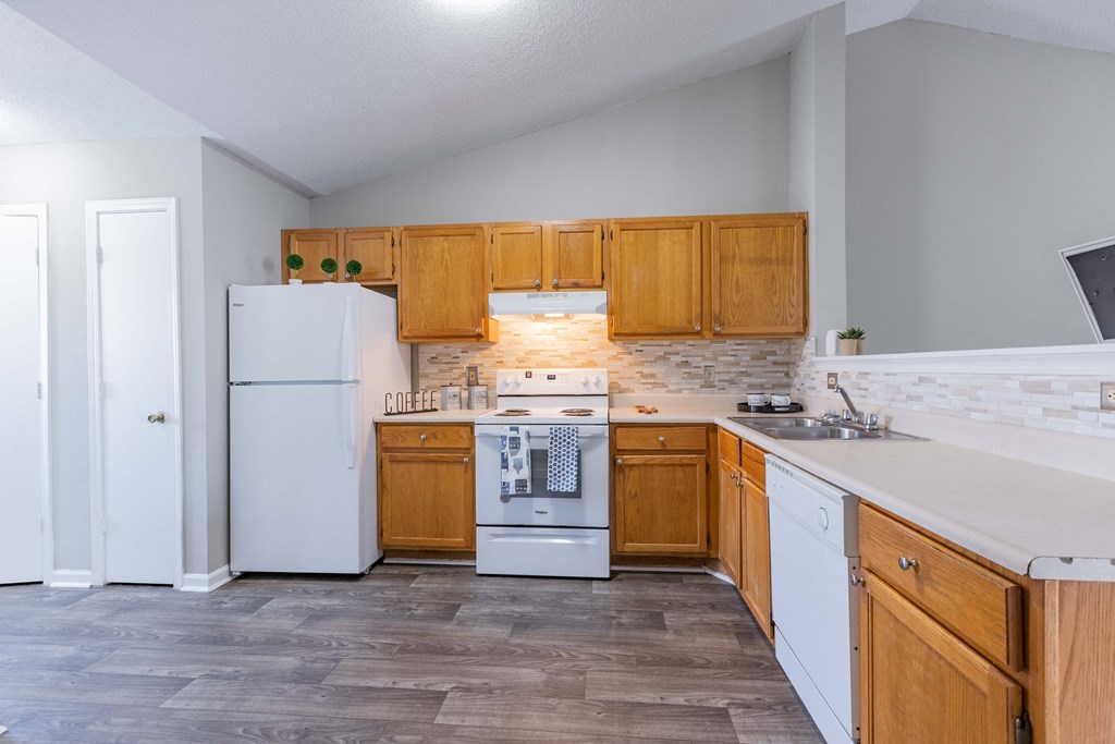 an empty kitchen with wooden cabinets and white appliances