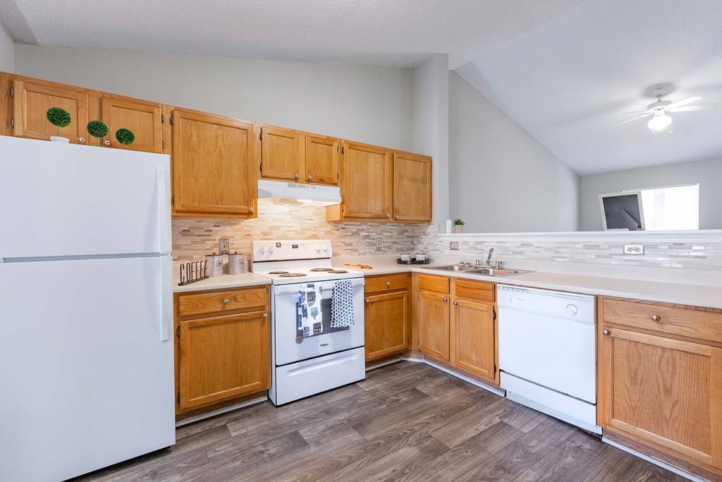 a kitchen with white appliances and wooden cabinets