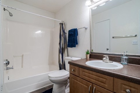 A bathroom with a white toilet, a white sink, and a white bathtub.