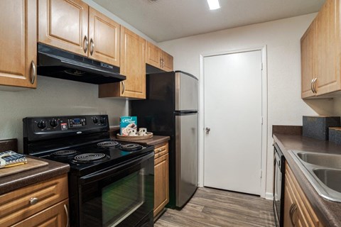 A kitchen with a black stove top oven and a black refrigerator.