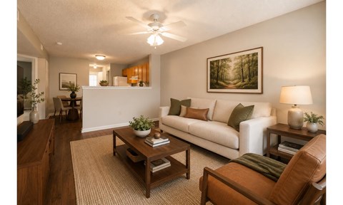 A living room with a white couch, a coffee table, and a painting on the wall.