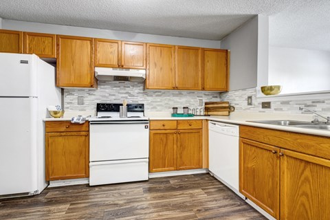 a kitchen with white appliances and wooden cabinets