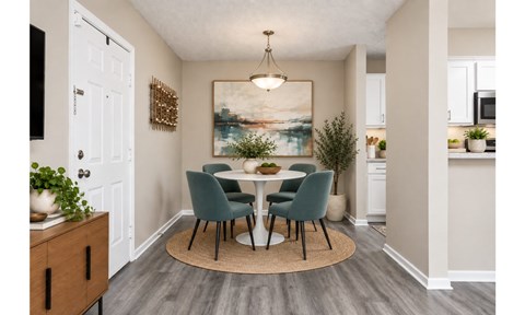 A dining room with a table set for four.