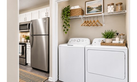 A modern kitchen with a stainless steel refrigerator and white appliances.