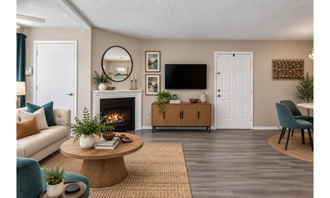A living room with a fireplace, a couch, a coffee table, and a TV.