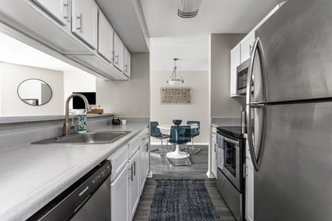 A modern kitchen with a large refrigerator and a dishwasher.