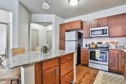 A kitchen with wooden cabinets and a granite countertop.