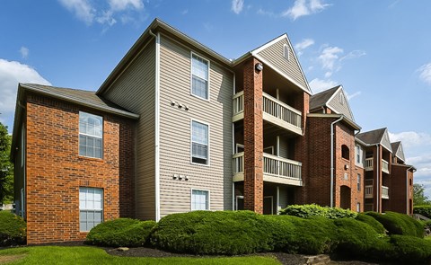 A row of apartment buildings with balconies and brick exteriors.