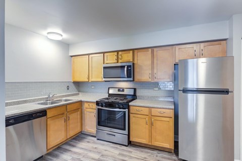 A kitchen with wooden cabinets and stainless steel appliances.