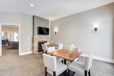 A dining room with a wooden table and grey chairs.