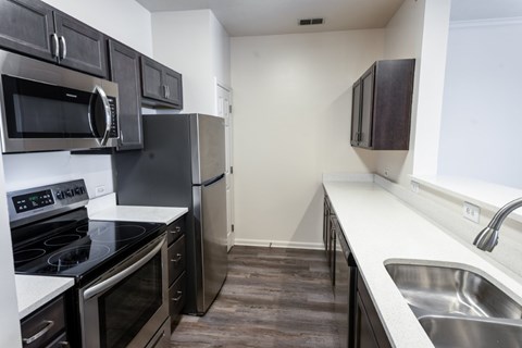 A kitchen with black cabinets and stainless steel appliances.