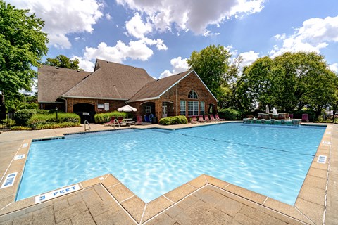 A large swimming pool in front of a house.