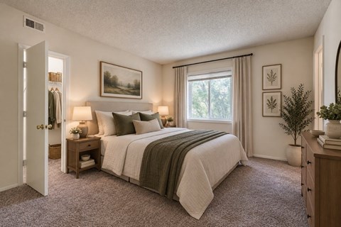 A bedroom with a large bed and a window with curtains.