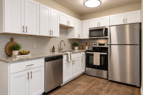 A kitchen with white cabinets and stainless steel appliances.