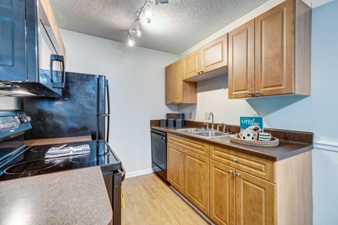 A kitchen with wooden cabinets and a black stove top.
