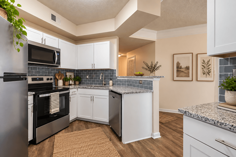 A kitchen with white cabinets and a black stove top oven.