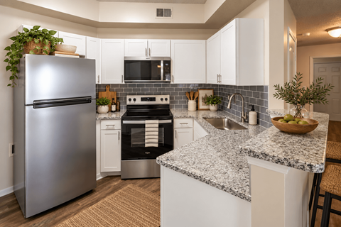 A modern kitchen with a stainless steel refrigerator and a black oven.