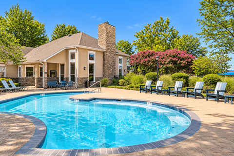 A house with a pool in front of it.