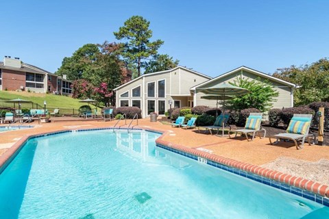 A large swimming pool with a building in the background.