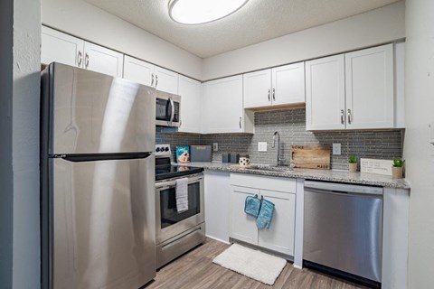 A kitchen with a stainless steel refrigerator and oven.