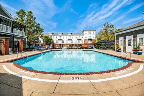a swimming pool at a hotel with a building in the background