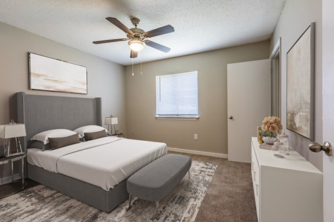 a bedroom with a large bed and a ceiling fan