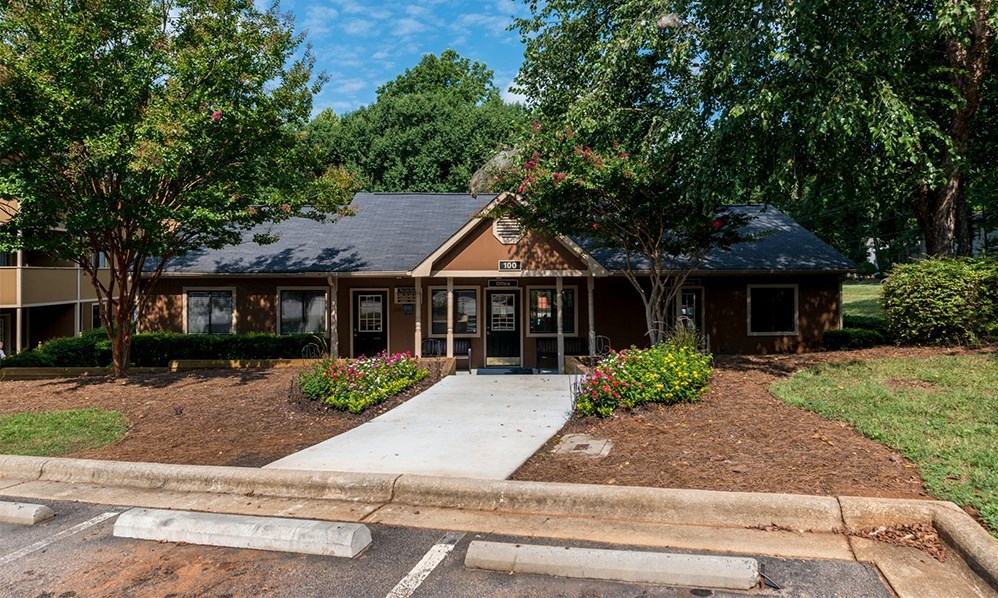 a house with a sidewalk and trees in front of it