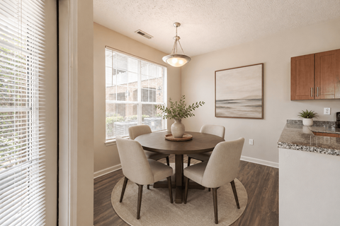 A dining room with a table and chairs.