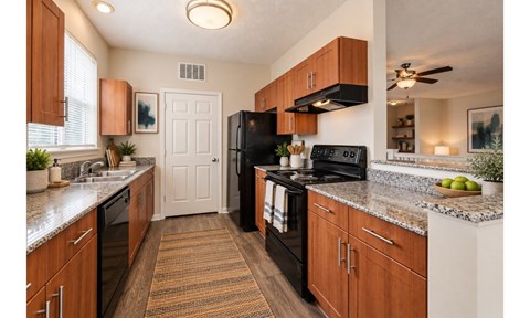 A kitchen with brown cabinets and a black refrigerator.