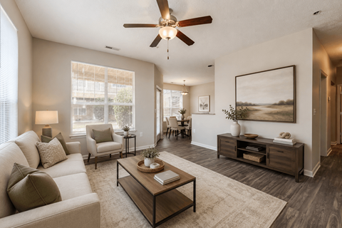 A living room with a white couch, a coffee table, and a ceiling fan.