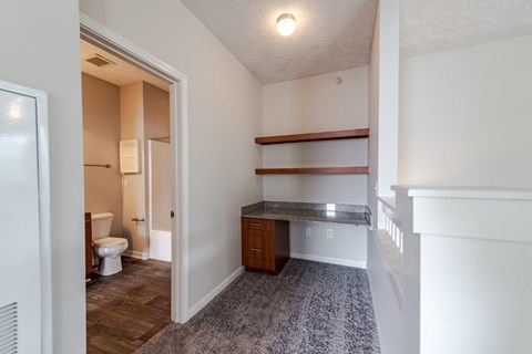 A bathroom with a toilet, sink, and a doorway leading to another room.