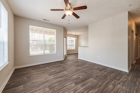 A room with a ceiling fan and wooden flooring.