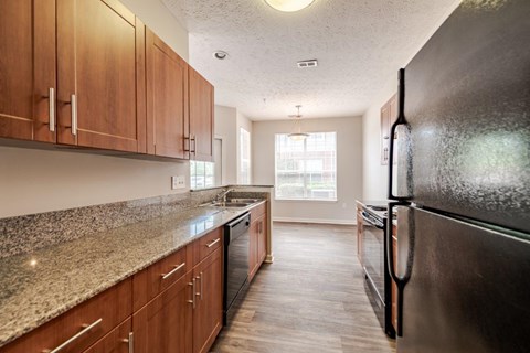 A kitchen with wooden cabinets and a granite countertop.