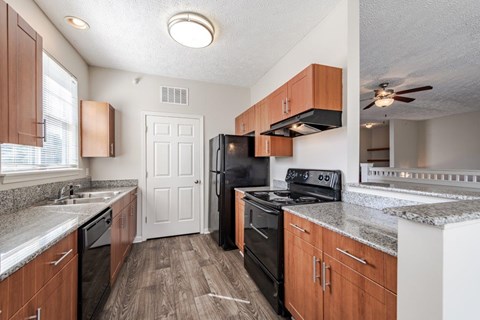 A kitchen with wooden cabinets and black appliances.