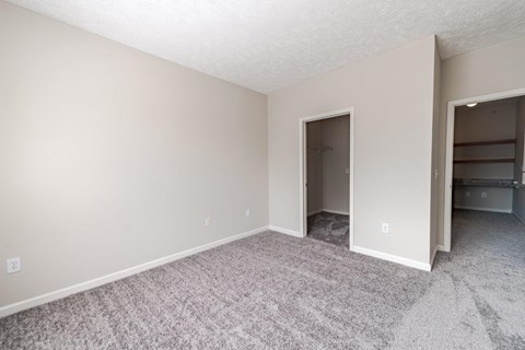 A room with a carpeted floor and a doorway leading to another room.