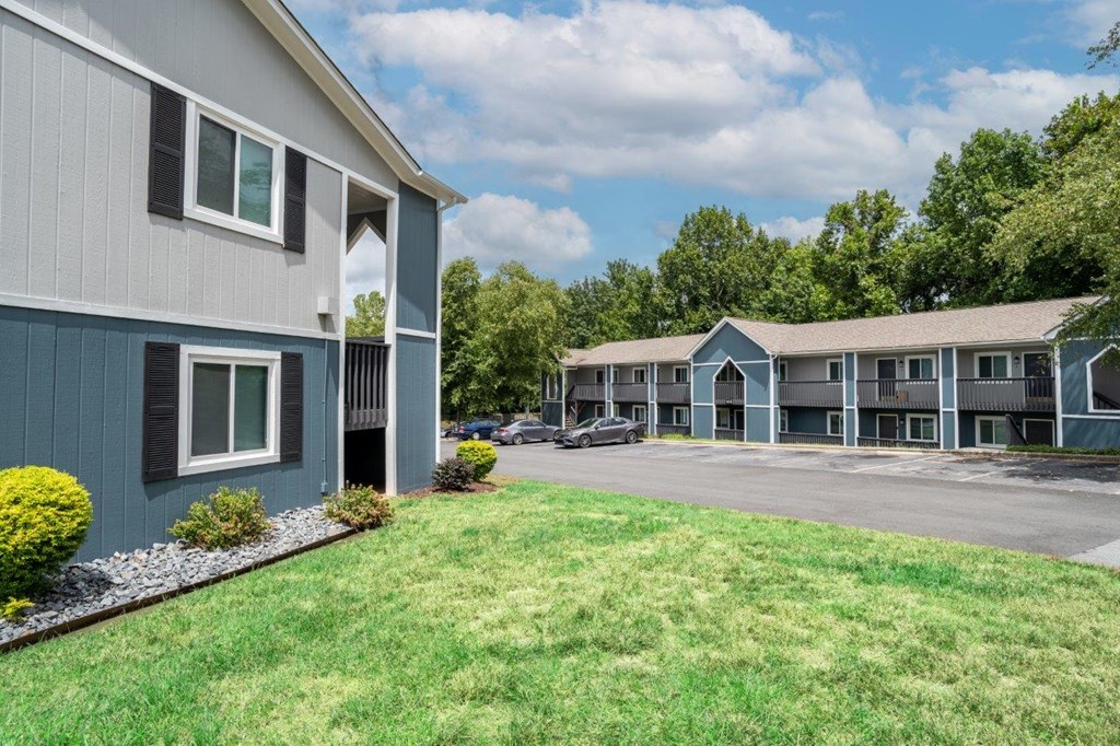 A building with a grey facade and a green lawn in front.