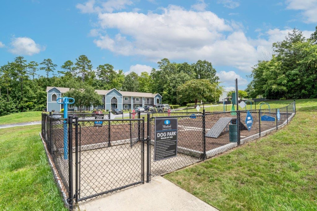 A dog park with a fence and a sign that says "DOG PARK".