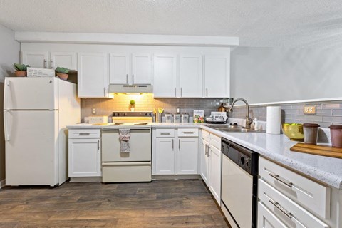 a kitchen with white cabinets and a sink and a refrigerator