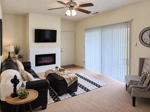 A living room with a fireplace, a couch, a chair, and a television.