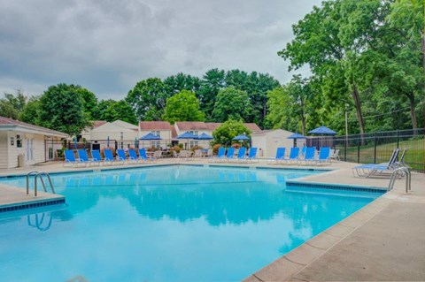 a swimming pool with blue chairs around it