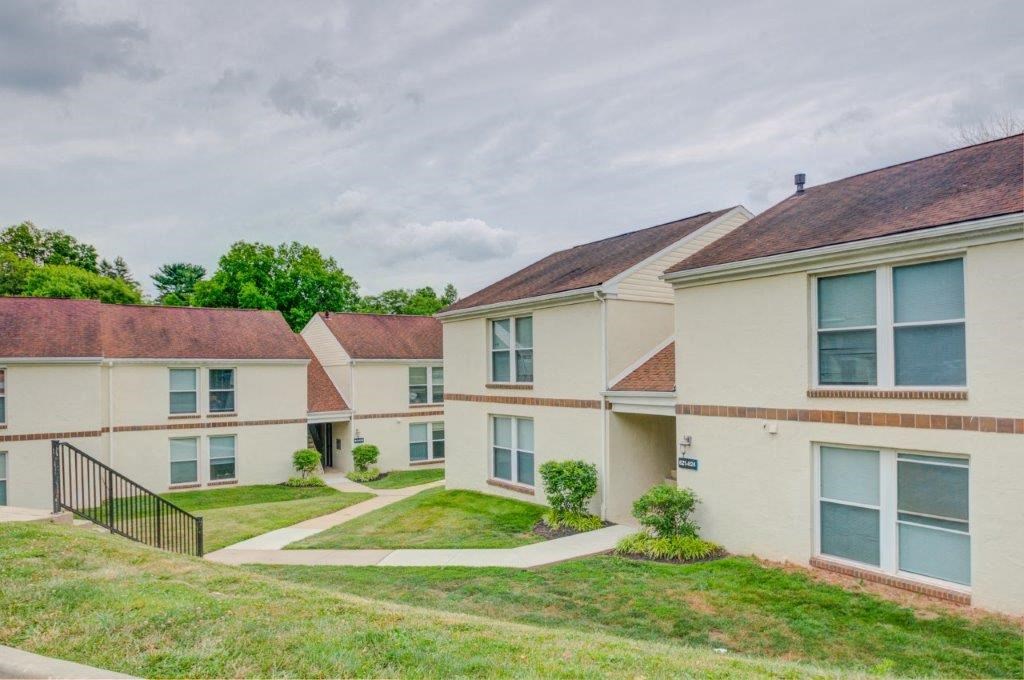 a row of houses with grass and a sidewalk