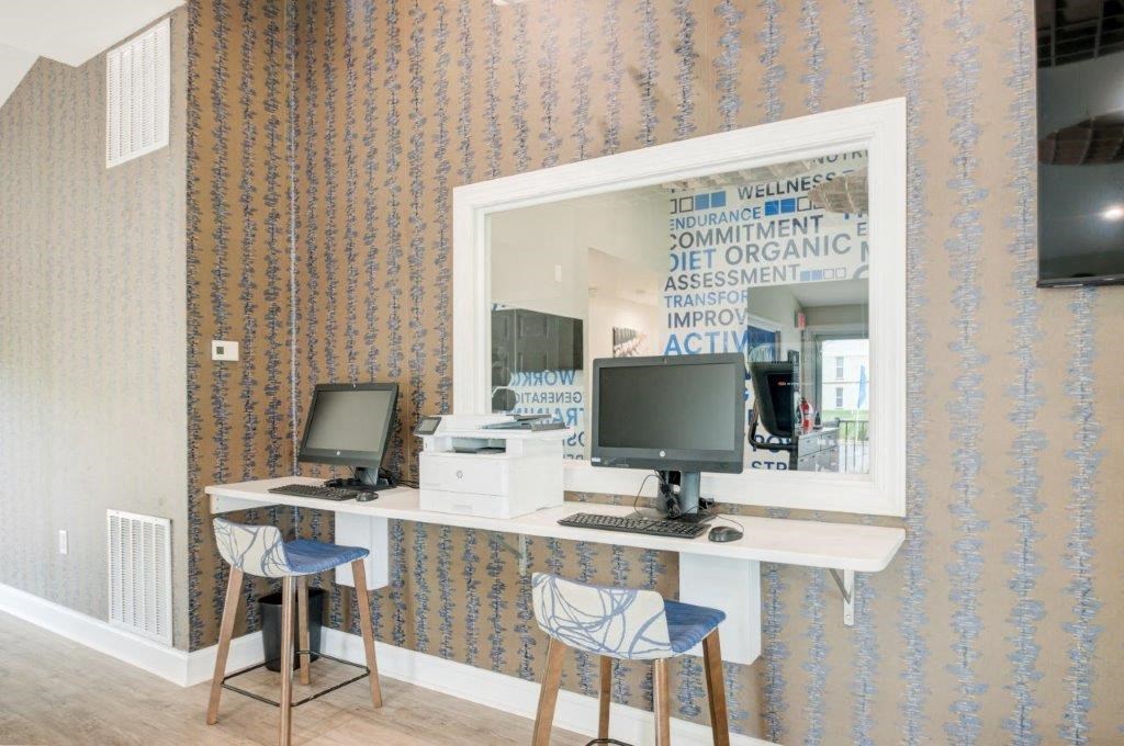 a mirror on the wall above a desk with a computer