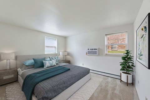 A bedroom with a large bed and a plant on the side table.