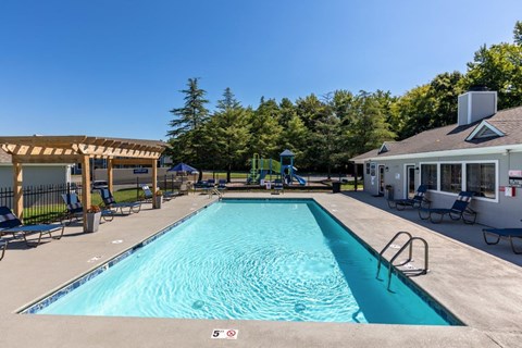 a swimming pool in front of a house with a resort style pool