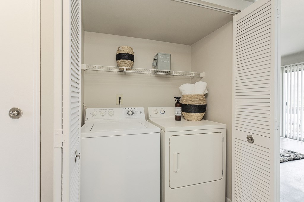 a utility room with a washer and dryer and a closet with white doors