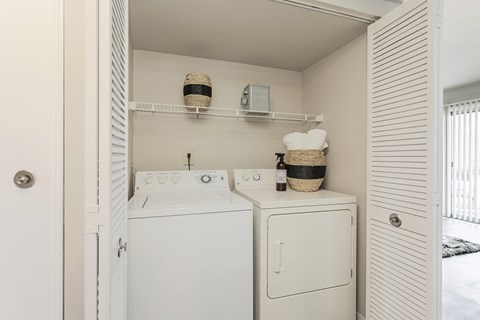 a utility room with a washer and dryer and a closet with white doors