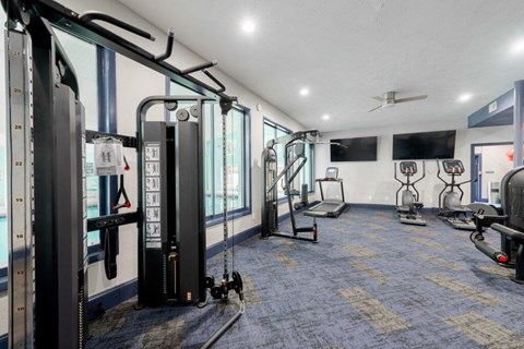 A gym with a variety of equipment including treadmills, stationary bikes, and weight machines.