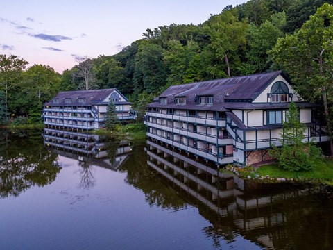 Two buildings are reflected in the water.