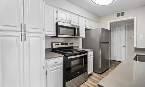A kitchen with white cabinets and stainless steel appliances.